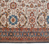 Large palmettes in denim blue and terra cotta beside the intricate arabesque main border.