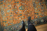 Orange rust field with dense gul ferang floral motifs and navy blue border.