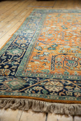 Orange rust field with gul ferang scrolling rose florals and navy meandering vine border.