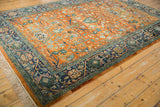 Corner view of vintage Indian Bijar rug, showing navy meandering vine border and orange rust field with fringe.