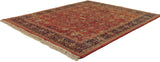 Vintage Indian Mahal carpet at an angle, showing its terra cotta floral field and navy border.