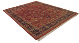 Angled view of a vintage Indian Mahal carpet showing the terra cotta field and navy blue border.