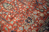 Close-up of Bijar rug's gul ferang scrolling rose motifs in rust, navy, blues, and greens.