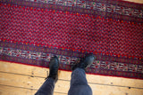 View down the vintage Tajabad runner's red boteh field and detailed wave border.