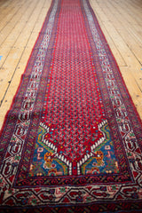 A long, angled view of the vintage Tajabad runner's repeating boteh field.