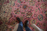 A detailed look at the floral palmettes and soft, full pile of a vintage pink Persian Tabriz carpet.