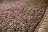 Plush hand-knotted pile of a vintage Tabriz carpet, showing the pink field and detailed ivory border.