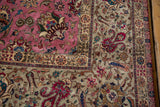 A vintage Tabriz carpet corner with intricate floral palmettes on pink and silver-ivory grounds.