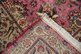 The intact side cord selvage and hand-knotted back of a vintage Persian Tabriz corner.