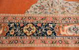 A vintage Tabriz carpet's silver spandrel and navy floral border against a rich terra cotta field.
