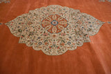 The large central medallion featuring a blue roundel, terra cotta details, and floral vinery.