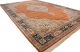 Angled view of a large Bulgarian Tabriz carpet showing the ornate corner, navy floral border, and plush pile.