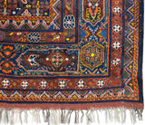 Stylized birds and geometric motifs within the paneled cartouche border of a collectible Afshar carpet.