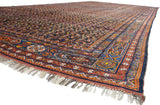 Perspective view of an antique Afshar carpet's scale, showing the paneled border and dense boteh field.