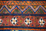 Paneled cartouche border detail on an antique Afshar carpet with sapphire, orange, and chestnut tones.