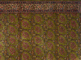 Ivory floral border contrasts with the rare green field of a collector's hand-knotted Kerman carpet.
