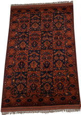 Vintage Taghan rug's paneled design in chestnut brown and navy blue, shown from an angle.