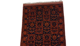 View of the vintage rug's fringe and paneled tree-of-life design in chestnut and navy.