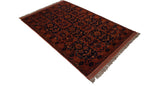 Full vintage Taghan rug seen from an angle, showing its paneled design in chestnut and indigo.