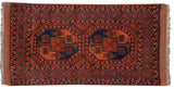 Corner of vintage Ersari rug, chestnut brown elephant gul and navy diamond lattice border.