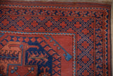 Corner detail of the geometric lattice border in madder root red and navy blue.