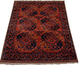 Angled view of a vintage Pakistani Ersari rug, showcasing its rich texture and geometric gul design.