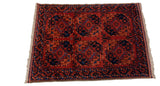 Angled view of a vintage Pakistani Ersari rug showing the full pile and geometric gul motifs.