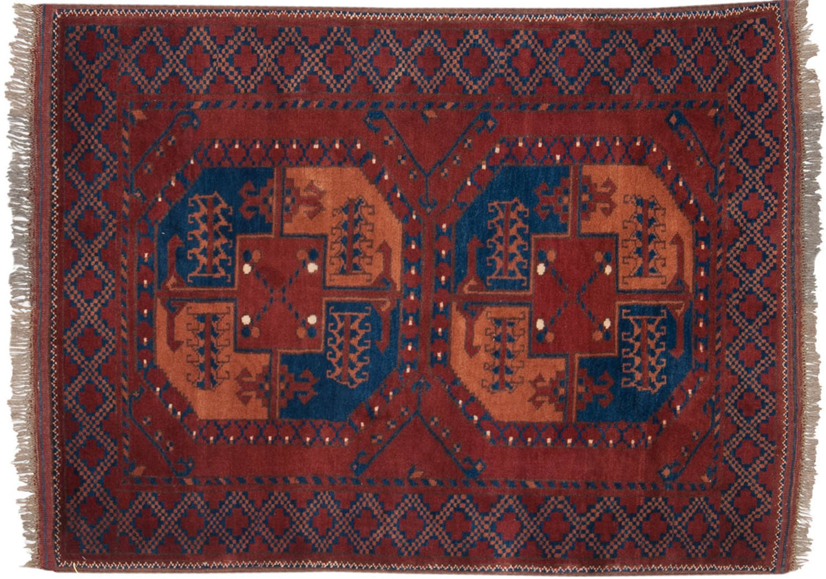 Vintage Pakistani Ersari rug with geometric guls in sapphire blue and apricot on a dark brick red field.