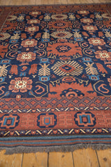 Close-up of Taghan carpet's dark copper, navy floral, finned plant, and boteh motifs.