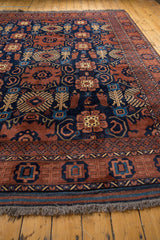 Fringe and geometric borders of the Vintage Taghan carpet in copper and navy tones.