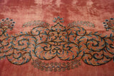 Rococo-style scrolling vine in sky blue and navy on a plush, dusty rose hand-knotted pile.