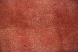 Texture of the Kerman carpet's full, even pile in mottled shades of cochineal red and rose.