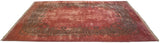 Angled view of a fine Kerman carpet with a plush dusty rose field and scrolling Rococo border.