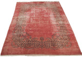 An angled view of the vintage Kerman carpet's open rose field and European Rococo border.