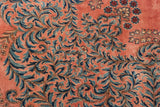 Close-up of the plush dusty rose pile with scrolling Rococo vines in sky and navy blue.