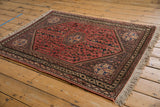 Vintage Abadeh rug corner, showing natural fringe and geometric blush, beige border.