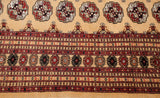 Detailed geometric border with minor medallions next to classic guls on a gold Bokhara carpet.