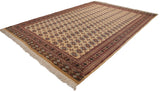 The full length of a vintage Bokhara carpet showing repeating gul medallions on a pale saffron yellow field.