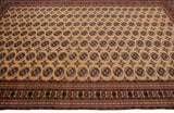 Perspective view of a vintage Bokhara carpet showing its repeating guls and detailed geometric border.