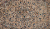 Scalloped trefoil contours of the central medallion on an antique Persian Kermanshah carpet.