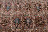 Detailed view of the vintage carpet's compartmentalized garden panels in brown, blue, and rust.