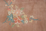 Soft rose and mint green ornate foliage on a plush Art Deco rug.
