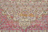 Close-up of the vintage carpet's millefleur field with floral vinery in pink, blue, and dusty gold.