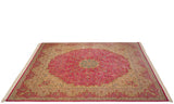 Low angle view of the vintage Kerman design carpet showing its pink medallion field and ivory border.
