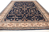 Angled perspective view of a vintage Indian carpet showing the sprawling navy blue and ivory Sarouk design.