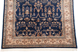 Ornate ivory floral border against the navy blue field of a vintage Indian Sarouk carpet.