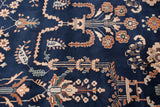 Ornate floral branches and buds in ivory, beige, and teal on the plush navy blue pile of a vintage carpet.