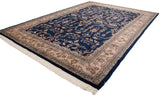 Angled view of a vintage Indian Sarouk carpet with a navy floral field and contrasting ivory border.