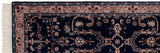 Traditional Indian Sarouk design rug corner with navy field, blush border, ornate floral motifs, and fringe.