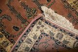 Intricate antique ivory and rose border of an Indian Mohajeran Sarouk rug with fringe.